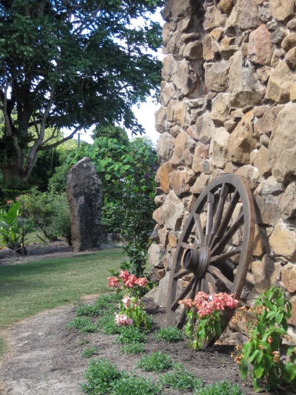 old cart wheel against stone wall